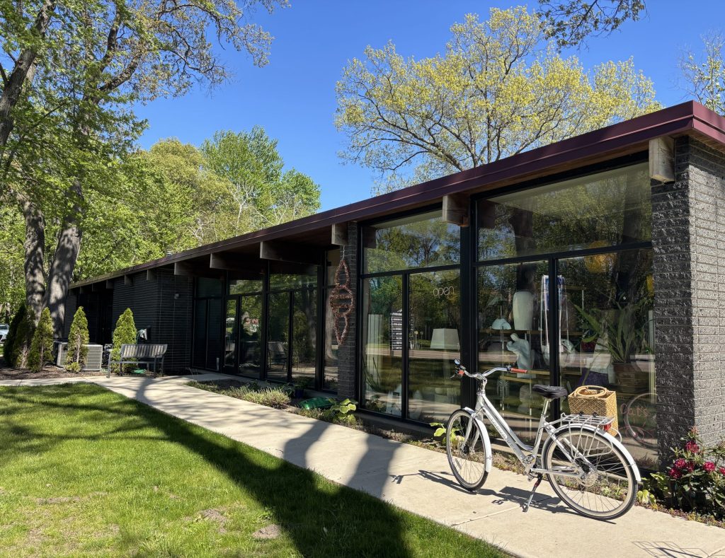a midcentury modern glass building with a bike in front.